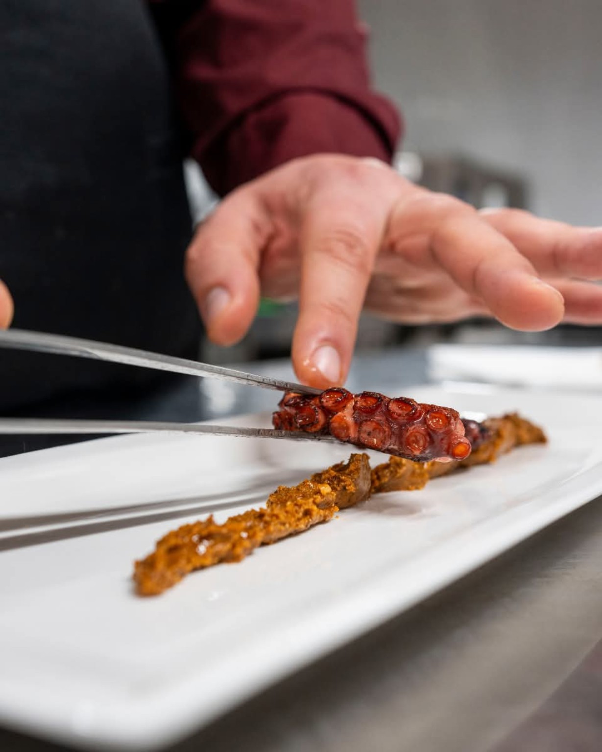 Chef plating an octopus dish